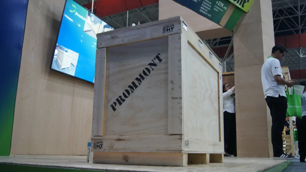 Gran embalaje industrial con logo Prommont en un stand, destacando la calidad de las cajas de madera.