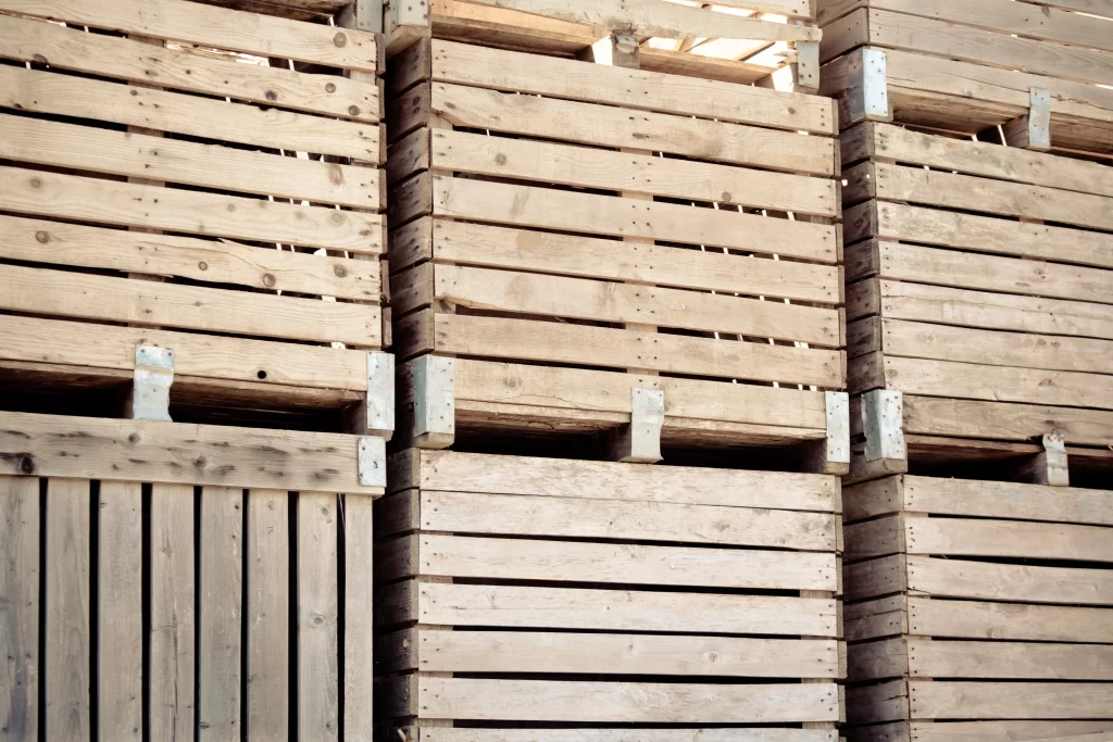 Gran cantidad de cajas de embalaje de madera apiladas en filas, formando una torre están prreparadas para envío.